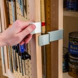 Person opening a cabinet with the Rockler Tandem Door Hinge Set