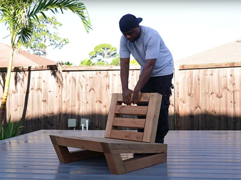 man standing near diy wooden outdoor chair