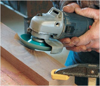Cutting crest section into rail with power grinder