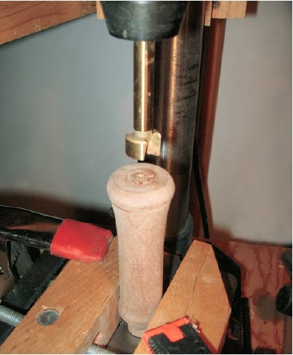 Cutting out storage compartment in screwdriver handle with Forstner bit`