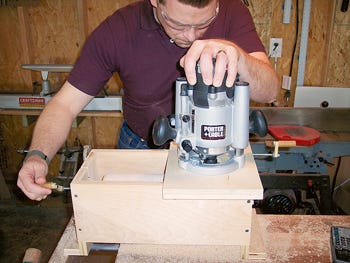 Sliding the router across the box jig to create groove spacing