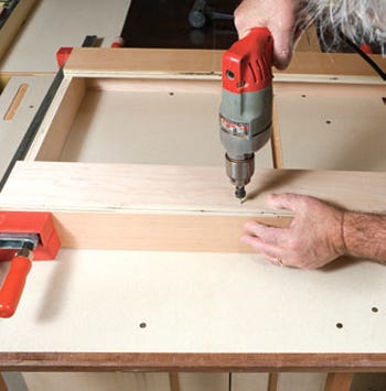 Screwing cabinet base cleats in place on frame
