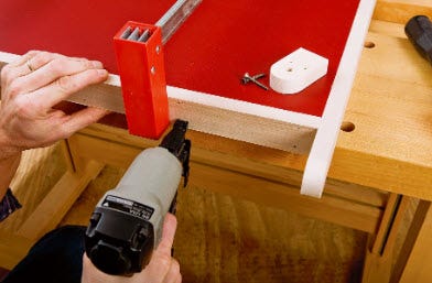 Using brad nailer to attach hardwood edging to outfeed table