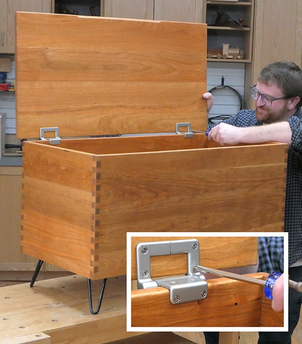 man attaching lid and hinges to blanket chest