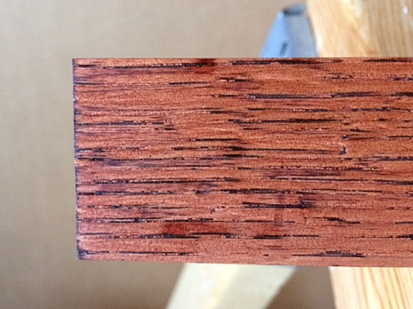 Stain bleeding into the pores of a piece of red oak lumber