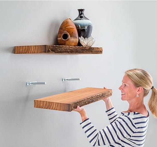 woman installing a floating shelf