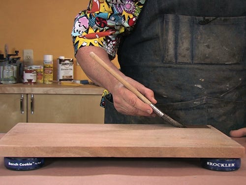 Using an oxtail finishing brush to apply varnish on wood