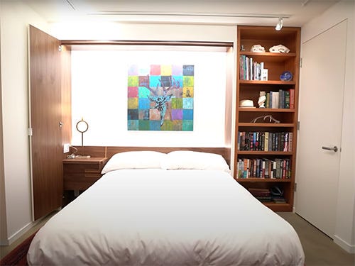 Murphy bed in wall with table, bookcase and lighting