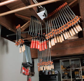 Hanging bar clamps from workshop ceiling rafters