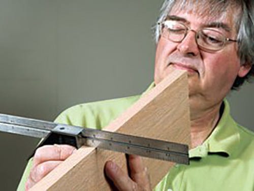 Checking edge and face of a piece of lumber with combination square