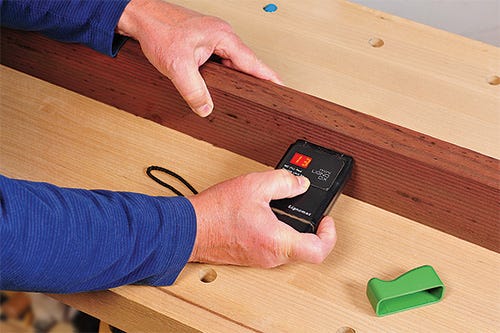 Checking the moisture content of a piece of outdoor furniture with a moisture meter