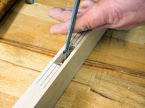 Using chisel to trim waste out of mortise