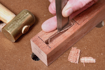 Shaving waste from mortise sides with chisel