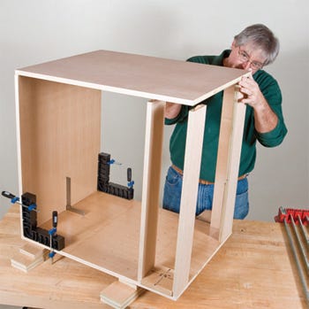 Using corner clamps to secure cabinet carcass during assembly