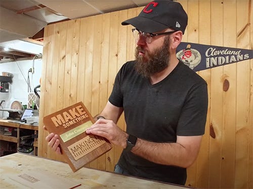 David Picciuto showing his custom wood and brass award plaque