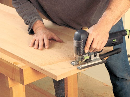 Using a jigsaw to shape the edges of the media center's top panel