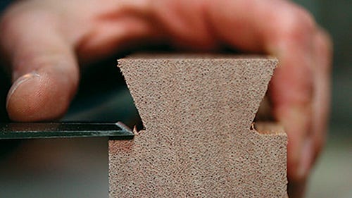 Using a chisel to clean up mini workbench dovetail joint