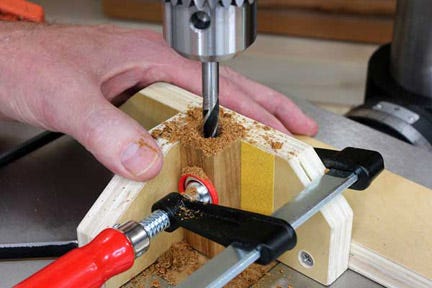 Drilling through center of blank set into vertical alignment jig