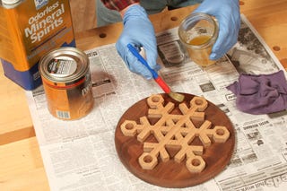 Wiping a mineral oil finish on a snowflake trivet project