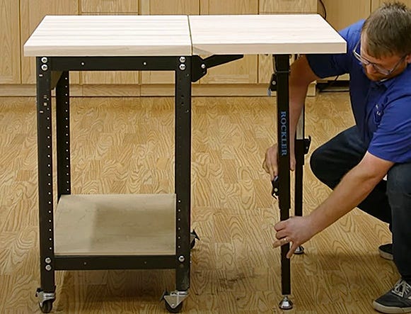 man adjusting leg height on folding work table extension