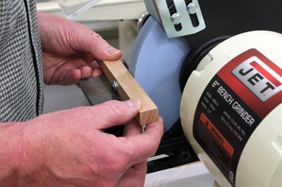 Using grinding wheel to flatten screw tip