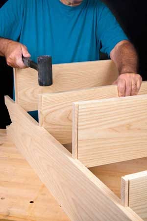 Using a rubber mallet to pound dovetails into place