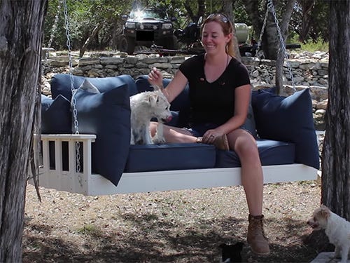 April Wilkerson and dogs sitting on hanging seat