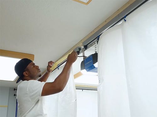 Hanging tarp from ceiling track for painting booth