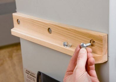 Fastening outfeed table leg ledge to side of cabinet saw