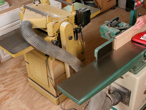 A full-size jointer and planer sitting next to each other in a workshop