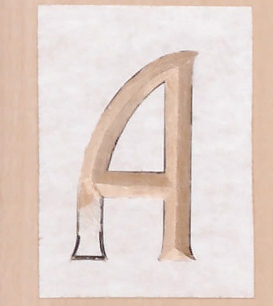 Letter A partially carved from a template