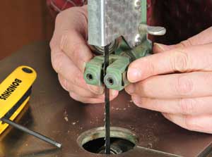 Tightening the lock screw on band saw guide block