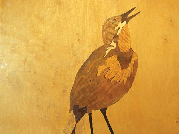 Image of a bird created in wood with marquetry inlays