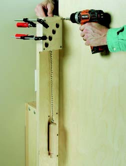 Screwing plywood panel holders into storage system