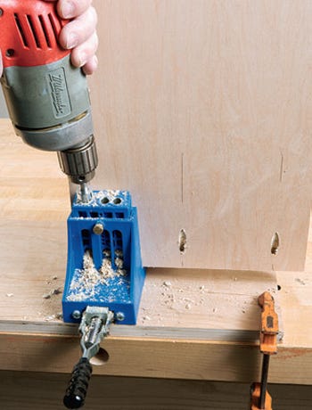 Using drilling guide to cut pilot holes in cabinet panel