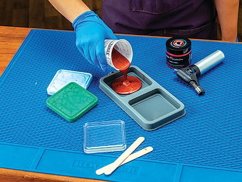 Pouring red colored epoxy into coaster mold