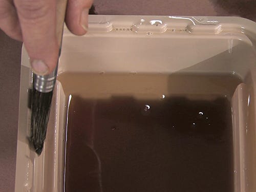 Scrape excess finish off end of brush using the finish pan