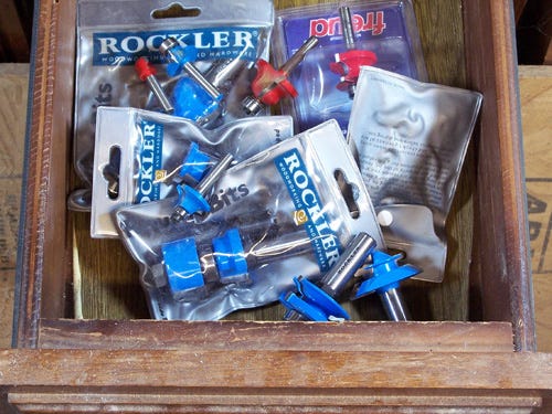 Router bits stored loose in a workbench drawer