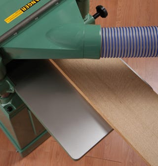 Feeding a rough-cut piece of lumber through a planer