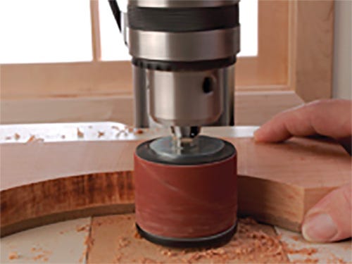 Using a sanding drum to smooth the curve in a woodworking part