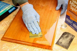 Using sandpaper to remove finish on a panel