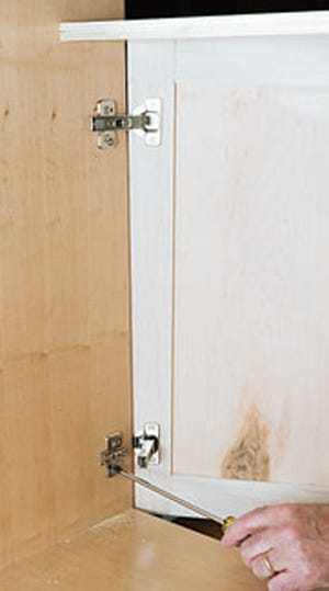 Installing door hinge plates in kitchen cabinet base