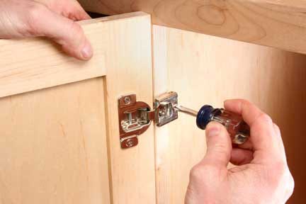 Using screwdriver to attach european hinge to cabinet base
