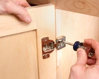 Using screwdriver to install european hinge on cabinet door