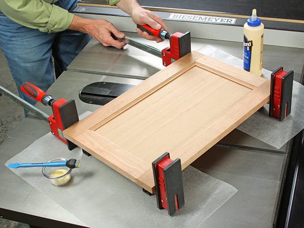 Clamping frame and panel door in cabinet construction