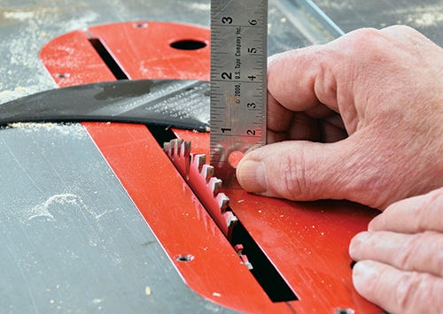 Using rule to measure height of table saw blade
