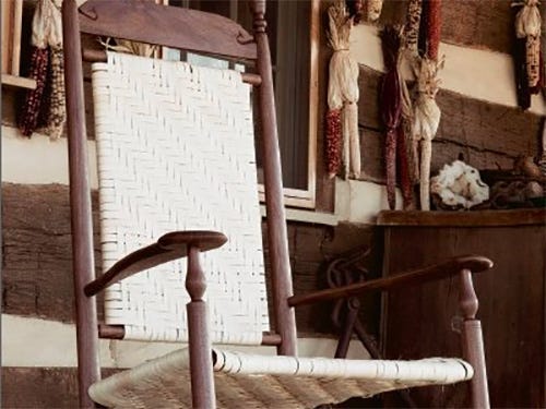 Classic rocking chair with woven seat and backing and turned legs and back