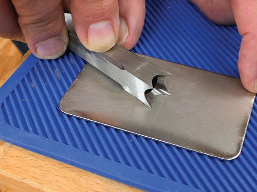Honing edge of mortising chisel with sharpening block