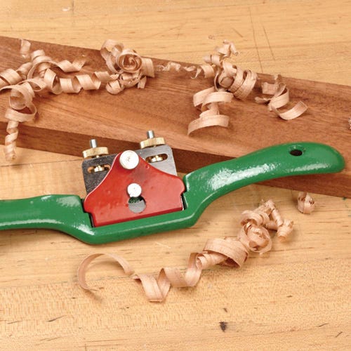 Spokeshave laying on a piece of lumber