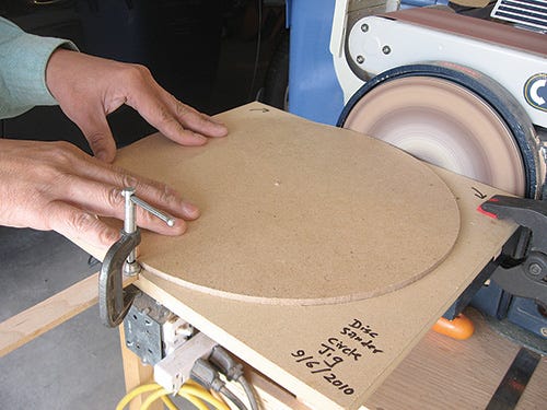 Rotating a panel along a disc sander to create a circle shape
